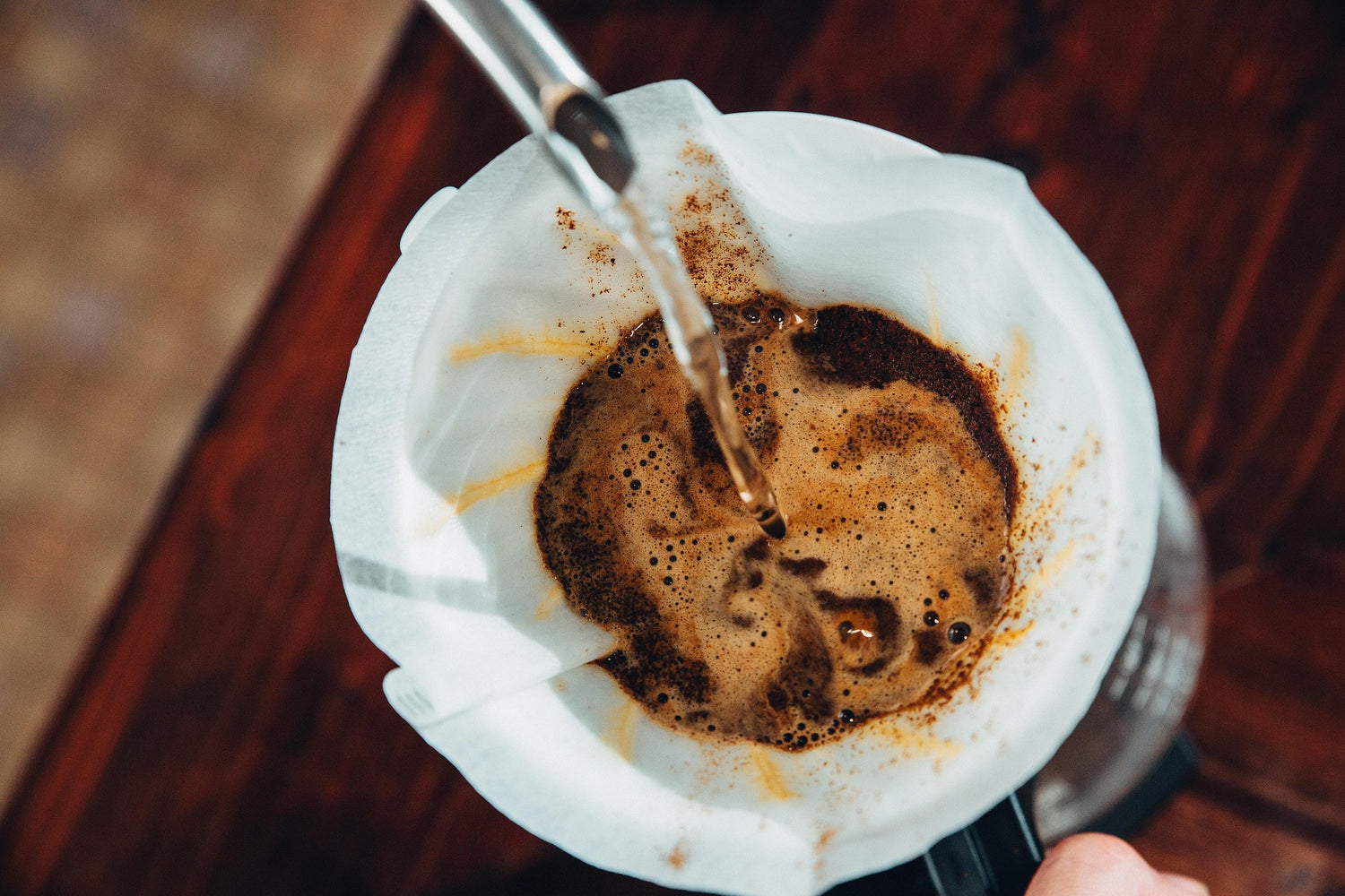 Filterkaffee wird in eine Kaffeekanne aufgegossen.