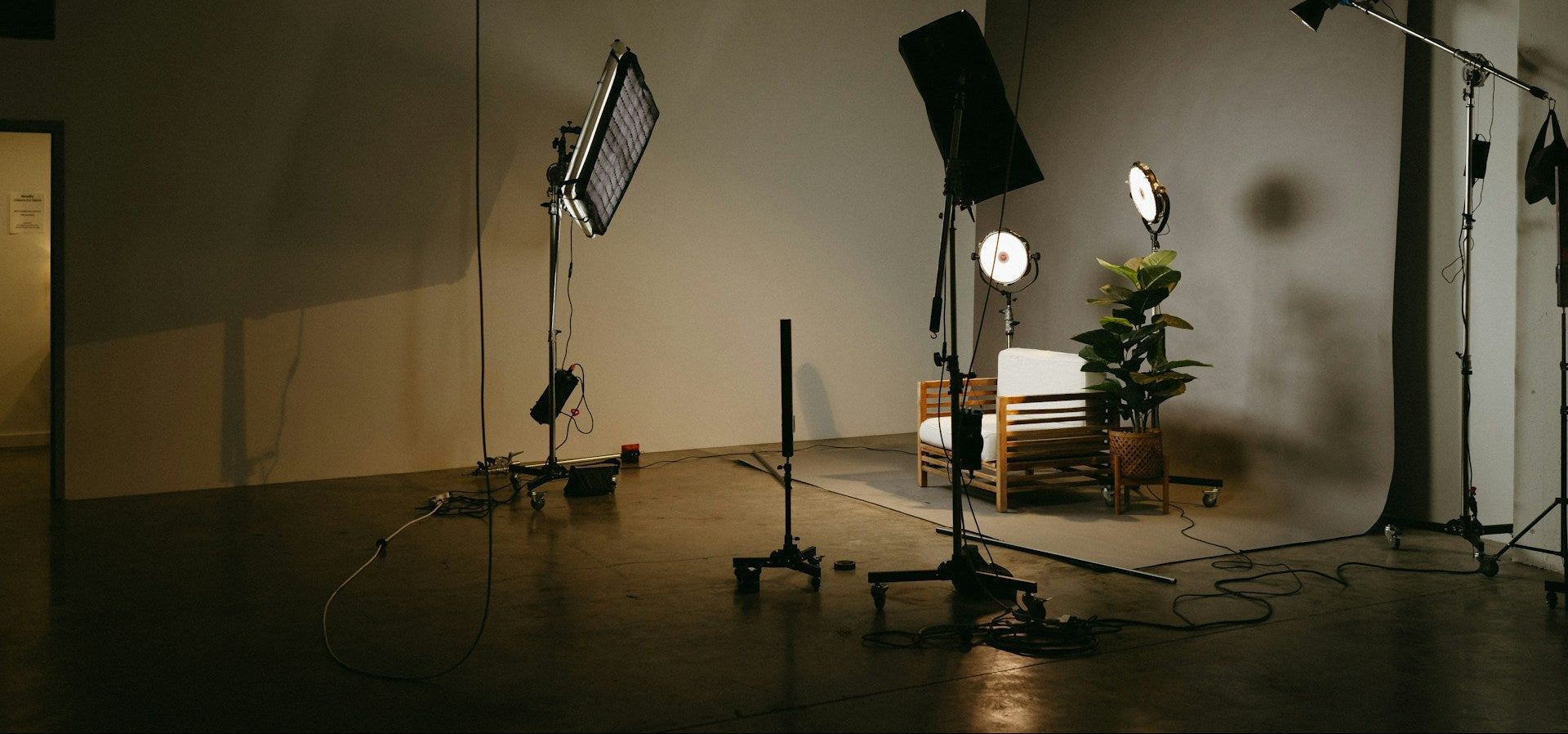 Ein angenehm beleuchtetes Aufnahmestudio mit einem Sitz und einer Pflanze im Bild.